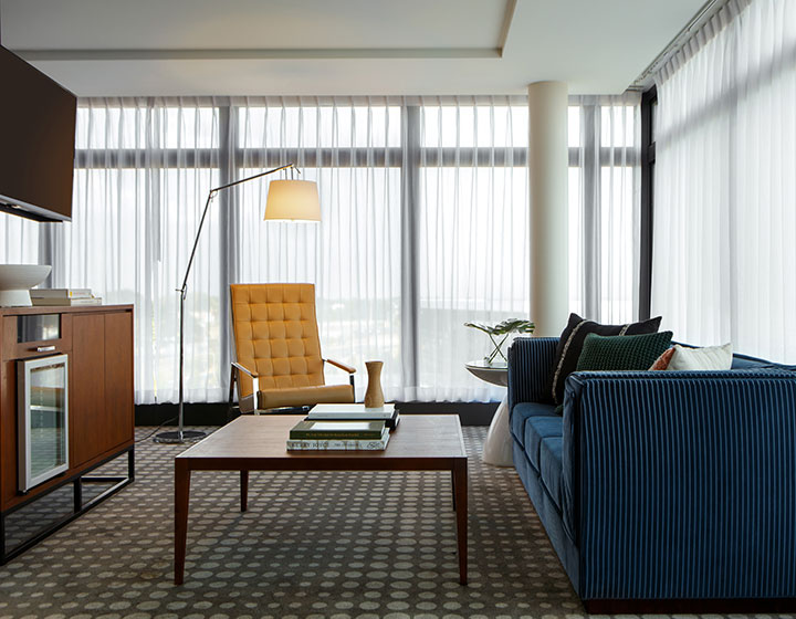 Couch, chair, TV and coffee table in suite sitting area at Kimpton Overland Hotel