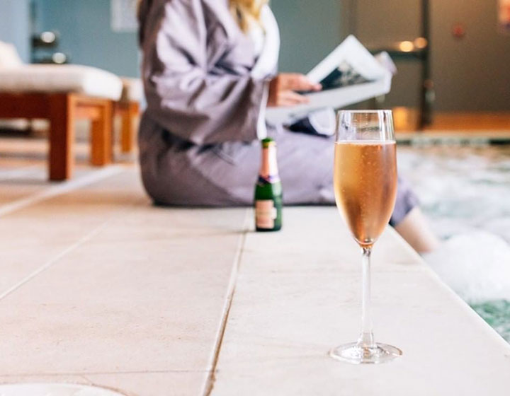Close up of a glass of champagne by the pool at Kimpton Overland Hotel